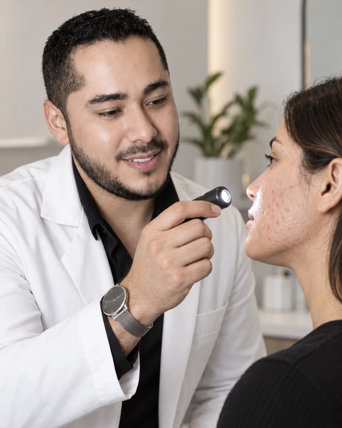 Dr. Barajas examinando acné y cicatrices faciales durante una valoración